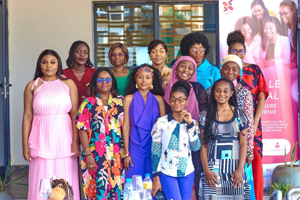 Women from the SheCode community pose in front of the Dare to go digital banner