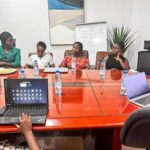 Participantes réunies autour d'une table de travail